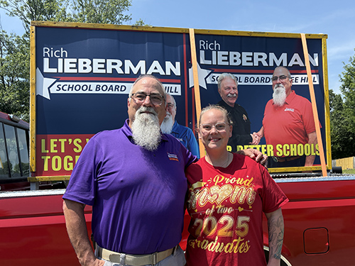 Rich standing with Mary Anctil in front of campaign signs