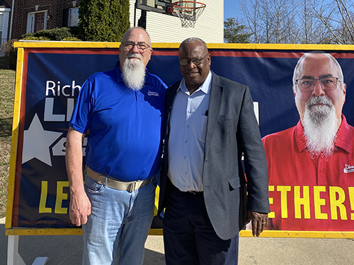 Rich standing with Baron Brasewell in front of campaign signs