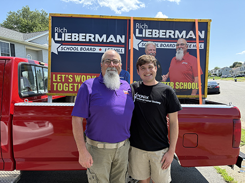 Rich standing with Jackson Huntley in front of campaign signs