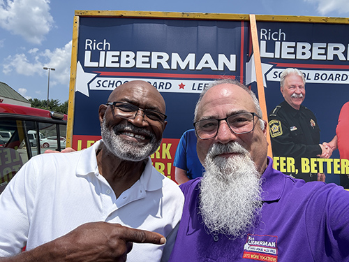 Rich standing with Mike Nelms in front of campaign signs